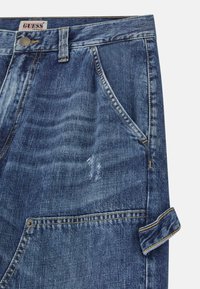 Pantaloni shorts in denim blu con un finish sbiadito, dotati di chiusura frontale con bottone, cinque tasche e orli arrotolati con cuciture a contrasto.