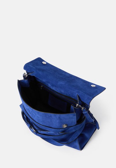 Μπλε σουέτ τσάντα με μαγνητική κλείσιμο καπάκι, εσωτερική τσέπη με φερμουάρ και ρυθμιζόμενο λουρί. Έχει λεία υφή και βαθύ χρώμα.