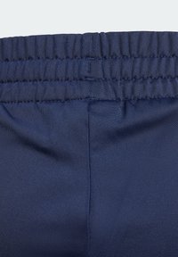 Námořnické modré elastické pásky s vroubkovanou strukturou, vyrobené z lehkého materiálu. Hladký povrch s mírným leskem a bez viditelných vzorů.