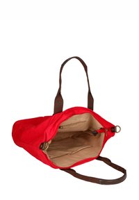 Borsa tote in tela rossa con manici in tessuto marrone, aperta per rivelare un interno beige con una tasca con zip e diversi scomparti.