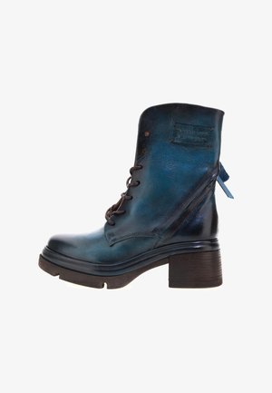 Bottine en cuir bleu avec un embout rond, un laçage à l'avant et un talon épais. Présente des coutures décoratives et une languette à l'arrière.