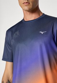 Kortærmet atletisk skjorte i gradient nuancer fra navy til orange, med subtile blomsterdesigns og et lille logo på venstre bryst.