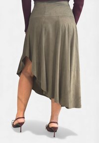 Gonna verde oliva asimmetrica con texture morbida, design svasato e orlo anteriore più corto, abbinata a sandali con tacco alto color borgogna.
