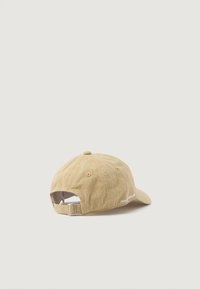 Gorra de algodón color caqui con visera curvada, correa ajustable en la parte trasera y detalle bordado en el lateral, con una superficie texturizada.