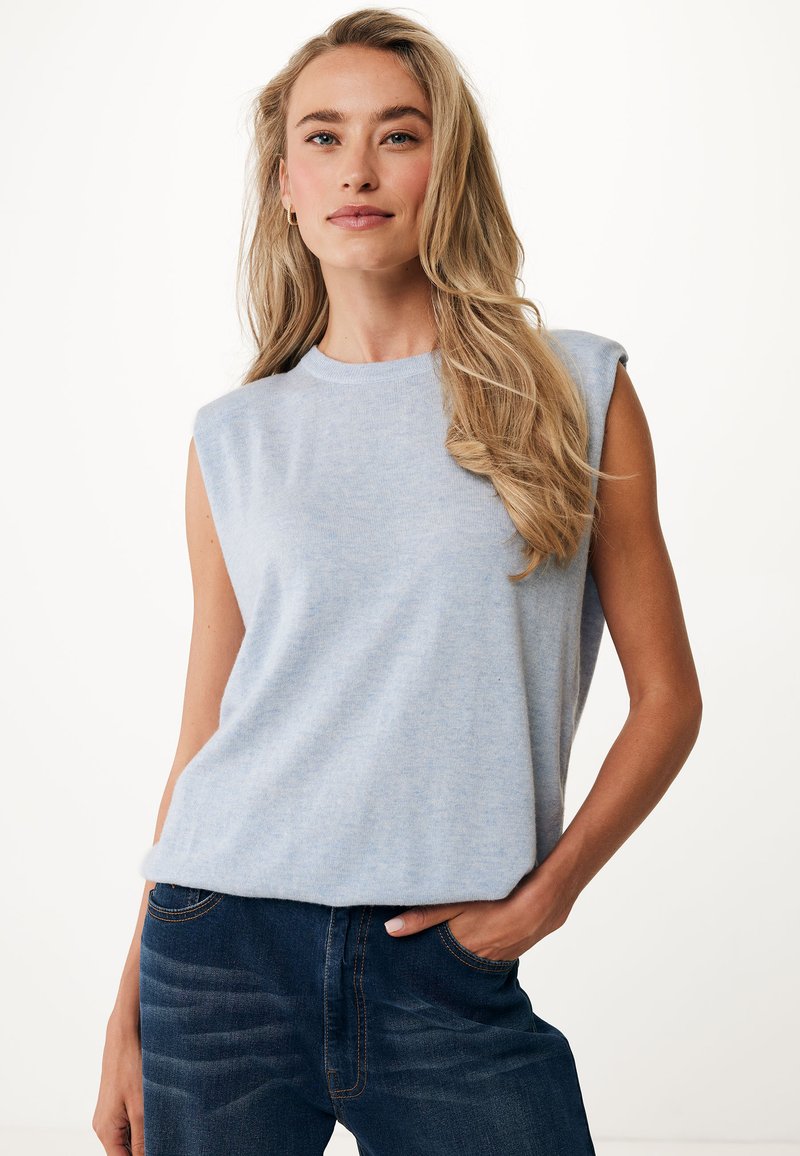 Světle modrý bezrukávový top z měkké tkaniny, s kulatým výstřihem a volným střihem, zkombinovaný s tmavě modrými džíny.