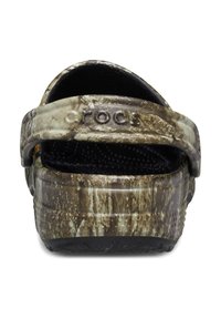 Sabots avec un motif camouflage, surface texturée, intérieur noir et une sangle à l'arrière pour un maintien sécuritaire, fabriqués en matériau léger et durable.