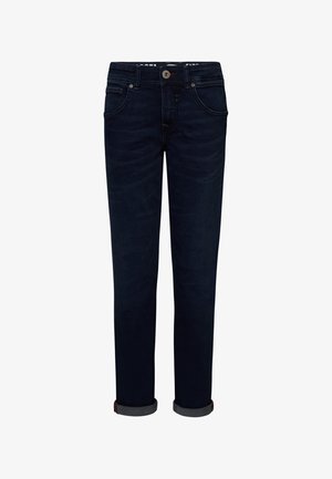 Camiseta de algodón azul con mangas cortas, cuello redondo y corte relajado, combinada con pantalones de mezclilla oscuros y zapatillas blancas con detalles en negro.