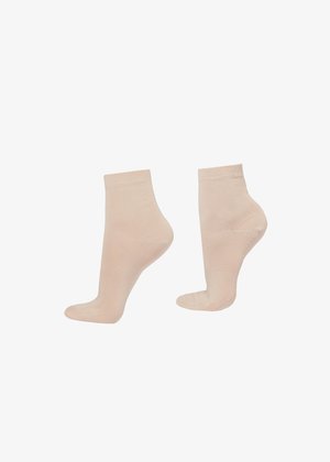 Par de calcetines tobilleros beige mostrados desde ángulos lateral y trasero sobre fondo blanco.