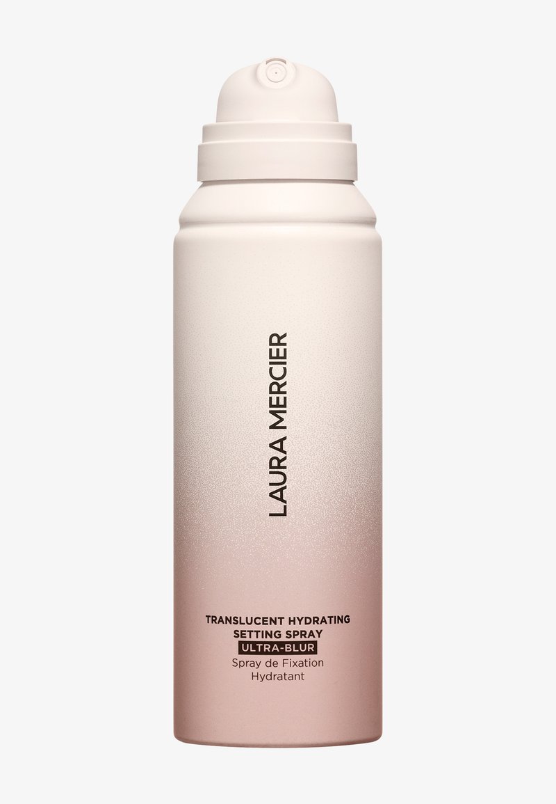 Przezroczysty spray utrwalający nawilżenie w cylindrycznym, ombre pojemniku, przechodzącym od bieli do różu, z pompką na górze i czarną etykietą z napisem.