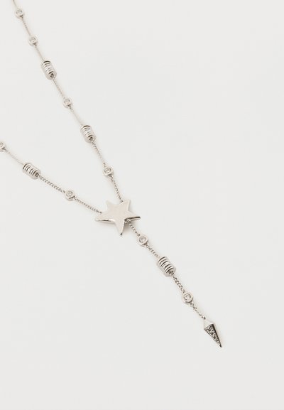 Sudraba kaklarota ar zvaigznes centrālo elementu, maziem apaļiem kristāliem, cilindriskām un trīsstūrveida dekoratīvām pērlēm uz smalkas ķēdīti, izlikta uz baltā fona.