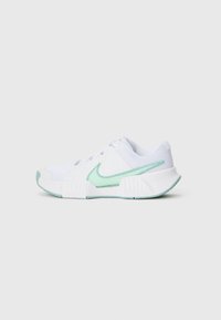 Zapatilla deportiva blanca con swoosh y acentos en turquesa claro de Nike, parte superior de malla, suela texturizada y cierre de cordones, vista lateral.
