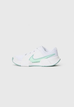 Zapatilla deportiva blanca con swoosh y acentos en turquesa claro de Nike, parte superior de malla, suela texturizada y cierre de cordones, vista lateral.