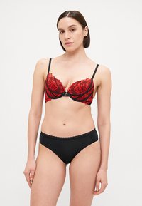 Rode kant ondergoed beha met bloemenpatroon en zwarte bandjes, gecombineerd met eenvoudige zwarte high-waisted slipjes met een geschulpte rand.
