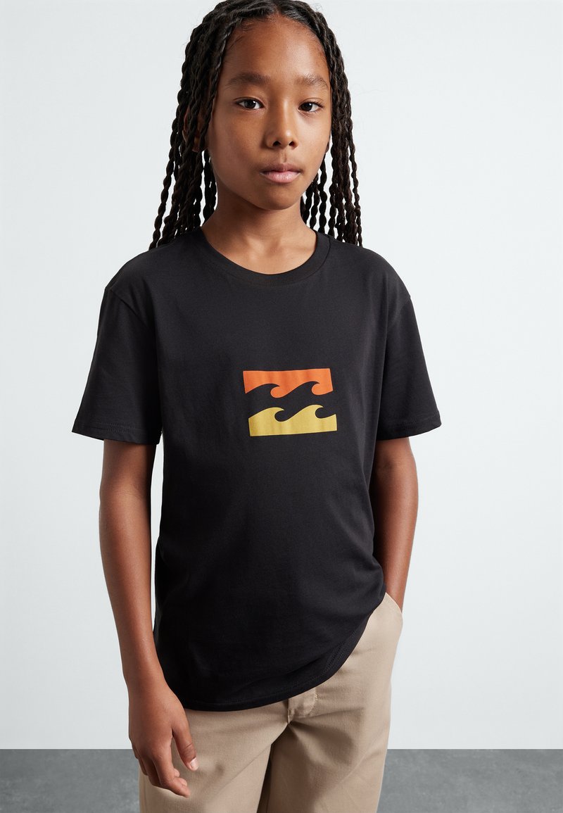 Camiseta de algodón negra con un logo de ola multicolor en naranja y amarillo. Manga corta, cuello redondo y corte relajado.
