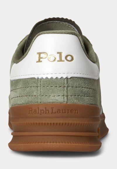 Žalios spalvos zomšiniai sportbačiai su baltu kulno tvirtinimu, auksiniu užrašu „Polo“ ir rudu guminis padu su iškilusiu „Ralph Lauren“ logotipu.