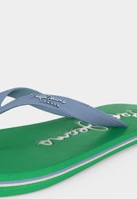 Πράσινο σαγιονάκι με ανοιχτό μπλε υφασμάτινα λουριά, με το λογότυπο «Pepe Jeans London» στο λουρί και ανάγλυφο λογότυπο στη σόλα.