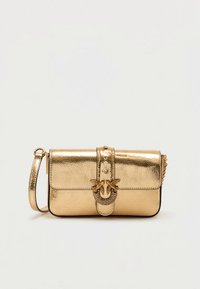 Χρυσή μεταλλική τσάντα με υφή, που διαθέτει μπροστινό καπάκι, διακοσμητικό κούμπωμα με λεπτομέρεια φιόγκου και αποσπώμενο λουρί ώμου.
