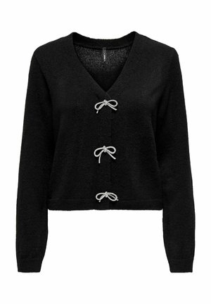 Melnā adītā džempera ar V veida kakla izgriezumu, garām piedurknēm un trim dekoratīvām sudraba lentu bantiņām kā aizdarām priekšā.
