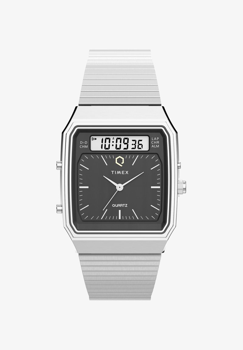 Montre numérique en quartz rectangulaire argentée avec un cadran noir, des aiguilles blanches et un bracelet en acier inoxydable ; comprend un affichage numérique et des boutons sur le côté.