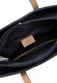 Borsa a tracolla in pelle blu navy con chiusura a zip, dotata di una tasca interna a scomparsa e di un'etichetta del marchio in pelle beige con dettagli di cucitura.