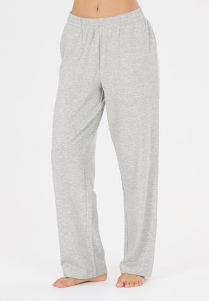 Pantalon de détente ample gris clair avec taille élastique, porté pieds nus, montré de la taille aux pieds sur un fond uni.