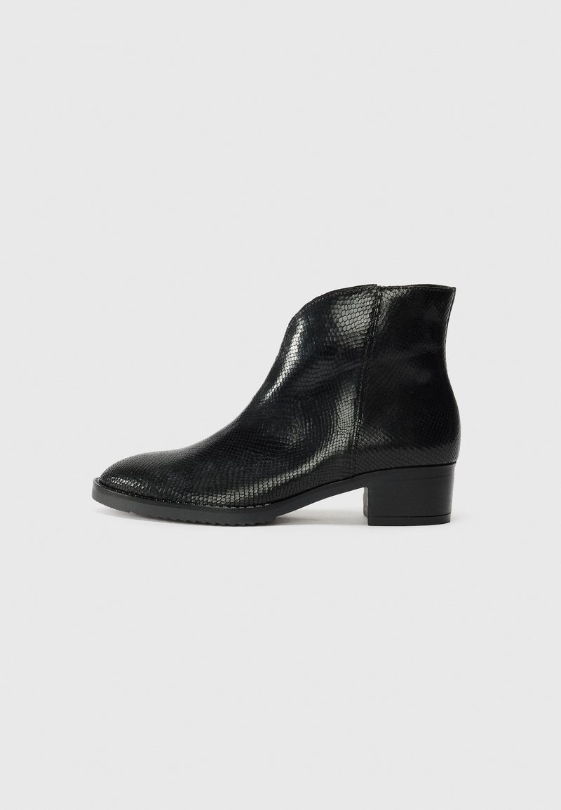 Black ankle boots made of textured material, featuring a low block heel and a smooth finish. Rounded toe and side zipper opening.