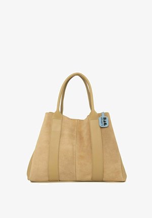 Beige tote bag made of suede with smooth leather accents. Features two long handles and a blue tag attached. Structured rectangular shape.
