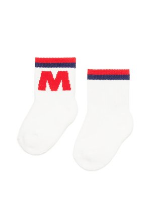 Calze di cotone bianche con una striscia rossa e blu navy sulla parte superiore e un grande logo rosso "M" sul lato. La texture è liscia e morbida.