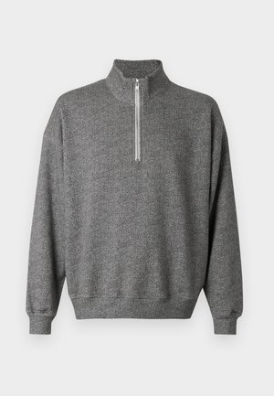 Sweat-shirt gris à chevrons avec col montant et fermeture éclair à quart. Comprend des poignets et un ourlet côtelés pour une finition texturée.