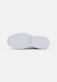 White sneaker sole with a textured pattern, featuring star-shaped impressions and a horizontal stripe design with branding. Smooth plastic material.