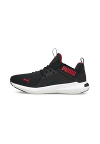 Chaussure de sport noire avec des accents rouges, tige en maille, panneaux latéraux texturés, semelle blanche rembourrée, et logo sur le talon et la languette.