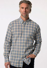 Camicia a quadri in beige, blu e nero. Presenta maniche lunghe, colletto e orlo curvo. Realizzata in tessuto tessuto.