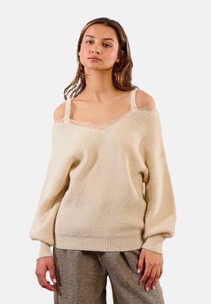 Maglione beige a spalla scoperta con motivo a maglia testurizzato, caratterizzato da dettagli in pizzo lungo il collo e maniche a sbuffo.