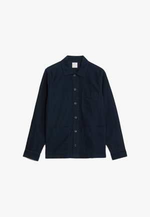 Námořnická modrá košile na knoflíky z bavlny, s límečkem, dlouhými rukávy, dvěma předními kapsami a náprsní kapsou s cedulkou uvnitř límce.