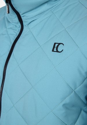 Light blue quilted jacket with black zipper and embroidered "EC" logo. Features diamond pattern and smooth texture.
