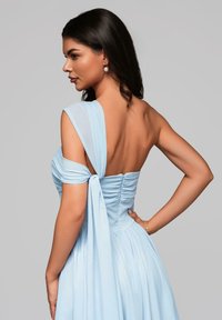 Abito blue chiaro con corpino aderente e arricciature, drappeggio su una spalla e gonna fluida. Tessuto morbido, elegantissimi legami e dettagli sul retro.