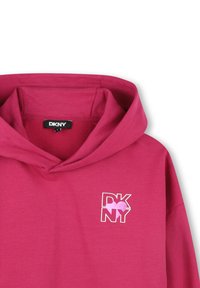 Felpa fucsia con tasca a marsupio frontale, cappuccio con coulisse e piccolo logo DKNY bianco e rosa stampato sul petto. Tessuto in cotone morbido.