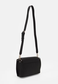 Black leather crossbody bag with a structured shape, adjustable strap, front flap, and gold-tone hardware accents. Textured surface.