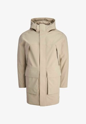 Giacca impermeabile beige con colletto alto, chiusura frontale con zip e due grandi tasche anteriori; texture liscia e design minimalista.