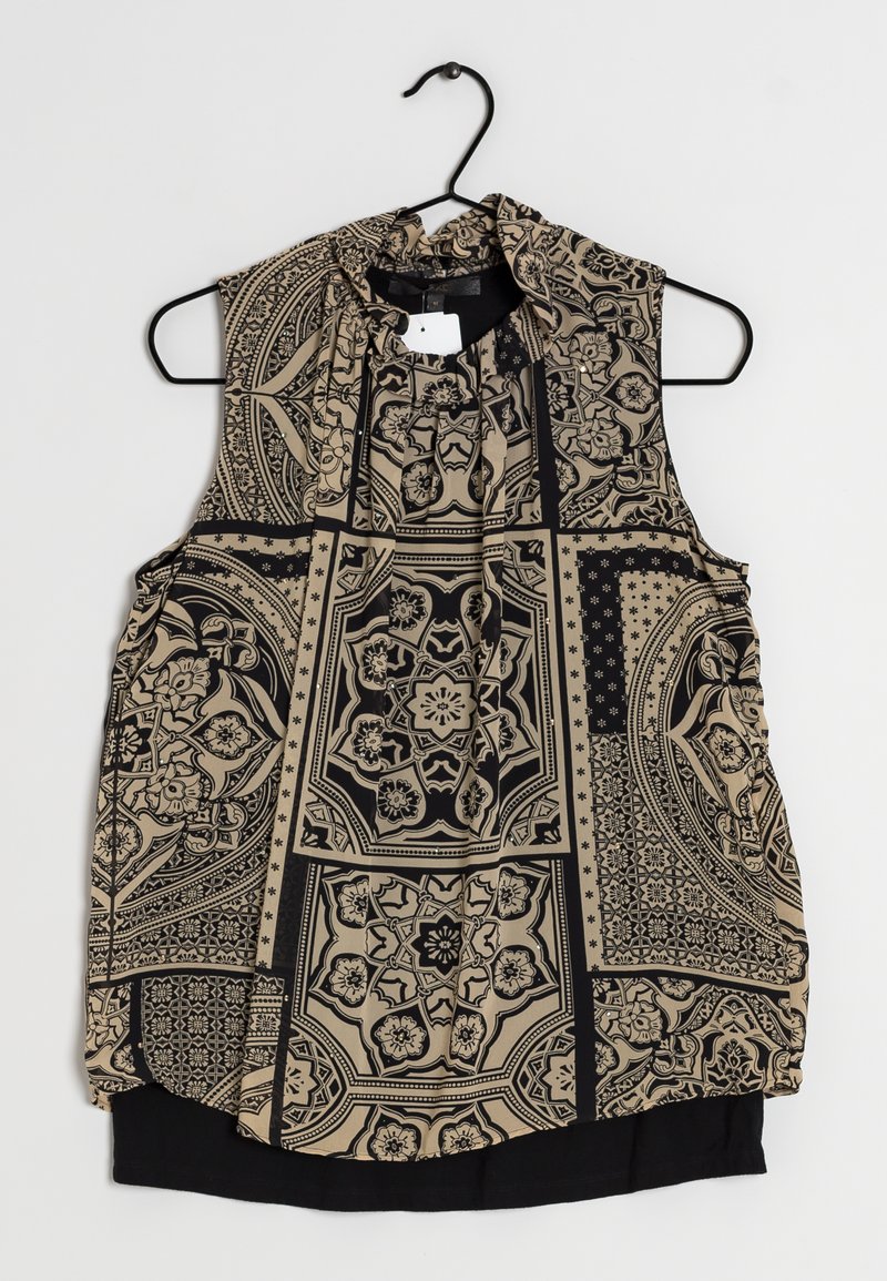 Blouse sans manches avec un motif complexe noir et beige, comportant des designs floraux et géométriques. Le tissu semble léger avec un col froncé.