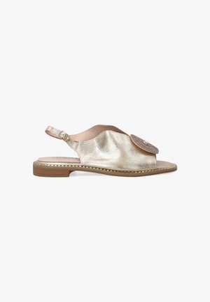 Guldmetallisk slingback-sandal med åben tå, dekorerende rund accent på overdelen og en flad gummisål. Glat tekstur og strømlinet design.