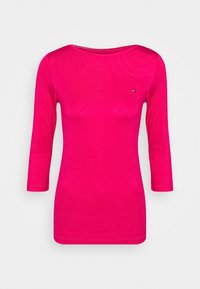 Fuchsia langærmet top med bådudskæring, lavet af letvægtsstof. Har et lille logo på brystet og en tætsiddende pasform.