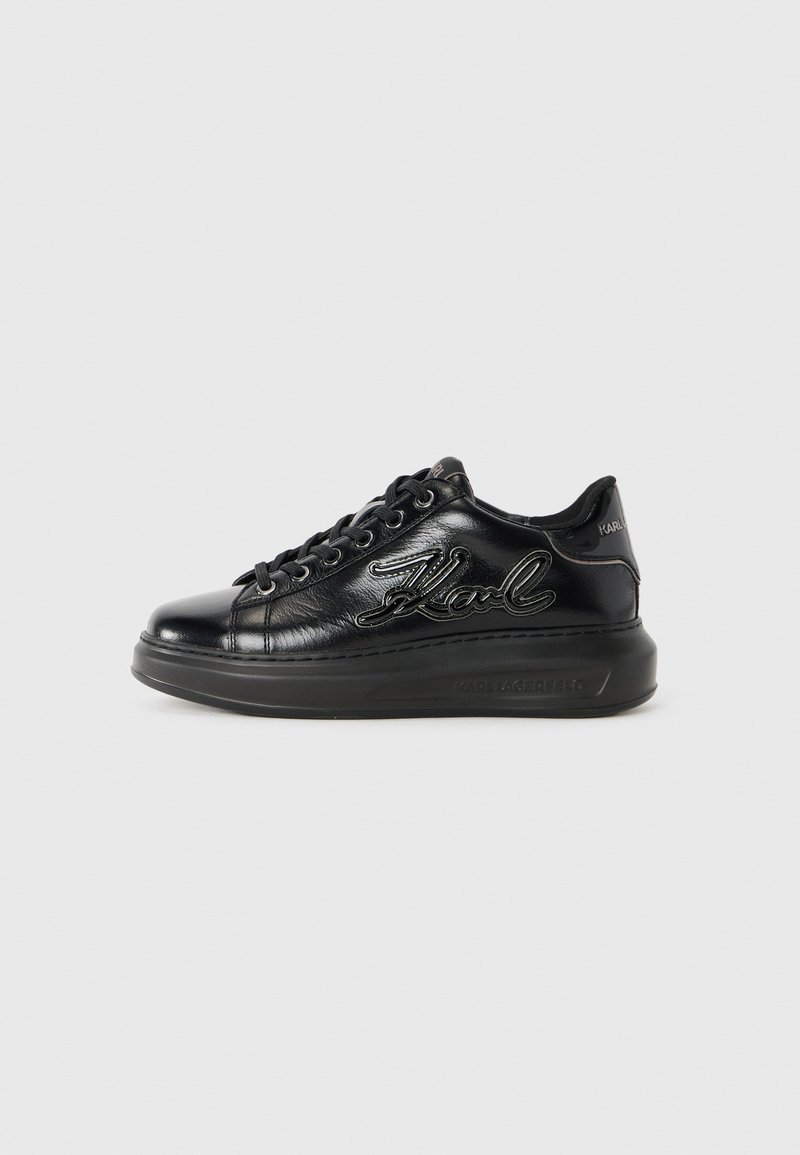 Black leather sneaker with black laces, thick sole, and "Karl" logo in bold cursive on side and "Karl Lagerfeld" embossed on sole.