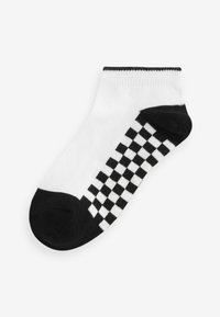 Svart och vit ankelsocka med ett rutigt mönster på sidan, tillverkad av mjukt tyg med förstärkt tå och muddar.