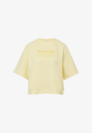 Lichtgeel shirt met korte mouwen en ronde hals, met de tekst "bloom bright" in een gele verlooplettertype op de voorkant.
