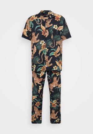 Chemise à manches courtes noire à motifs floraux et pantalon assorti, ornés de léopards orange, de feuilles vertes et de fleurs brunes dans un design tropical.