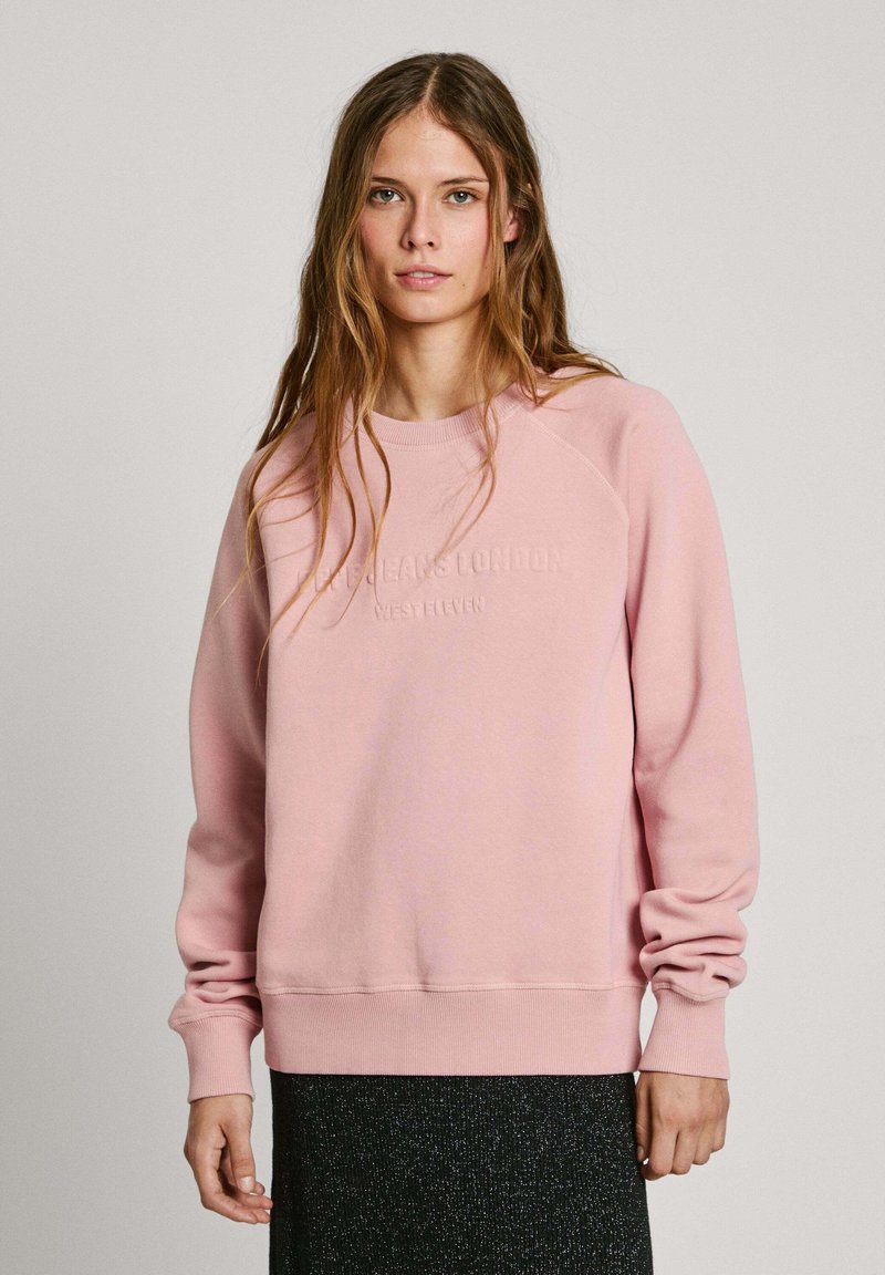 Felpa rosa chiaro con scollatura a girocollo e maniche raglan. Presenta testo in rilievo sul davanti e polsini e orlo elasticizzati.