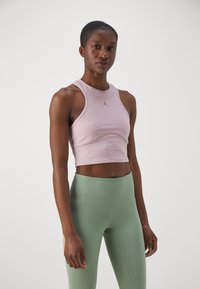 Rosa kortermet treningsgenser med rund hals og racerback-design, kombinert med høytlivs grønne leggings med en glatt tekstur.