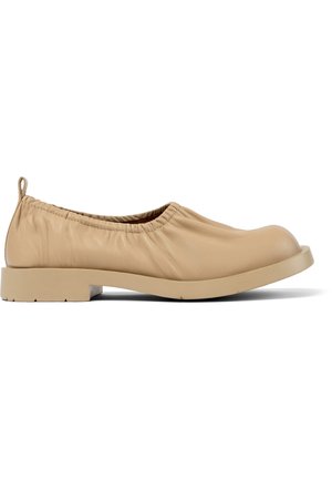 Scarpa beige in pelle slip-on con bordo superiore arricciato, punta arrotondata e tacco basso a blocco. Texture liscia con dettagli minimi.