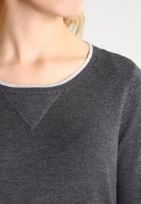 Charcoal gray sweater with a rounded neckline. Features a light gray trim at the collar and textured knit fabric with a seamless look.